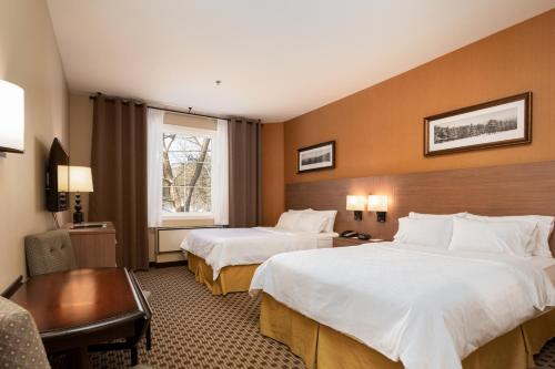 Habitación de hotel con 2 camas y escritorio en Holiday Inn Express & Suites Tremblant, an IHG Hotel, en Mont-Tremblant