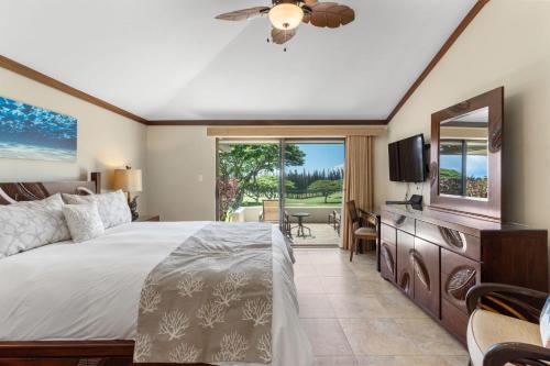 um quarto com uma cama grande e uma televisão em Sun, Beach, Golf Romantic Getaway! A Safe Place em Kahana