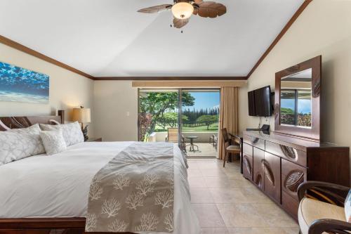 a bedroom with a large bed and a television at Sun, Beach, Golf Romantic Getaway! A Safe Place in Kahana