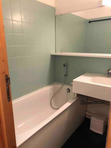 une salle de bain avec un lavabo, une baignoire et un miroir dans l'établissement Studio 4 personnes proche des pistes, à La Plagne Tarentaise