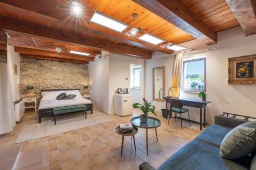 a living room with a bed and a piano at DOLF - Porta Gemina in Urbisaglia