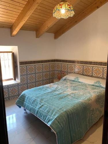 a bedroom with a bed and a chandelier at La carchata ático in Siete Aguas