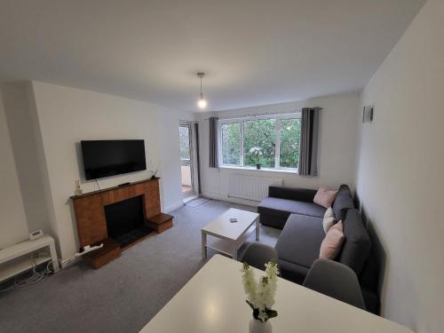 uma sala de estar com um sofá e uma televisão em Modern 3 bed Walking Distance to Wimbledon Tennis! em Londres