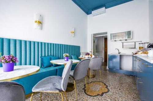een keuken met blauwe muren en een tafel en stoelen bij Hold Rome - Luxury Suites in Rome
