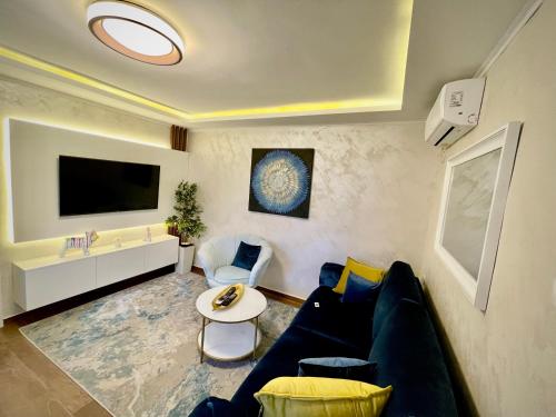 a living room with a blue couch and a tv at Apartment Lena Niksic in Nikšić