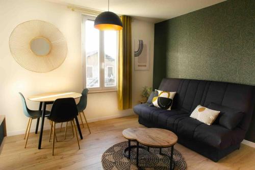 een woonkamer met een zwarte bank en een tafel bij Appartement Proche Hôpital La Tronche in La Tronche