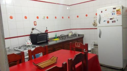 cocina con mesa roja y nevera blanca en Departamento gde a 1/2 cuadra plaza Indep. cochera en San Miguel de Tucumán
