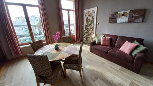 uma sala de estar com uma mesa de vidro e um sofá em STUDIOS ET APPARTEMENTS EN CENTRE VILLE Boulogne sur mer em Boulogne-sur-Mer