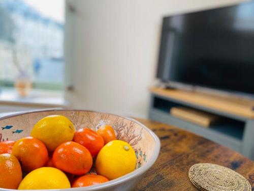 a bowl of oranges and lemons sitting on a table at Vindelis Cottage Chesil Beach in Portland