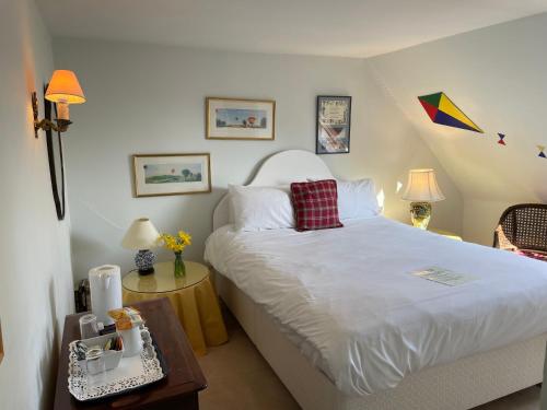a bedroom with a large white bed and a table at Langrish House in Petersfield