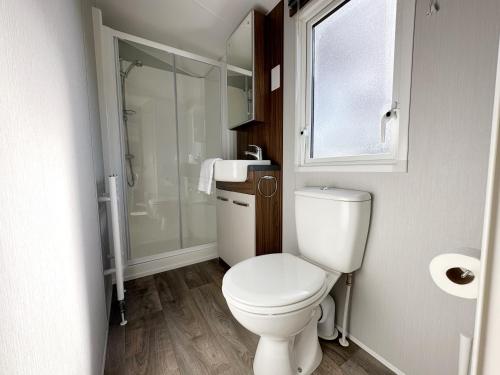 een kleine badkamer met een toilet en een douche bij Chalet 550 op Recreatiepark de Wielen in Sint Maarten