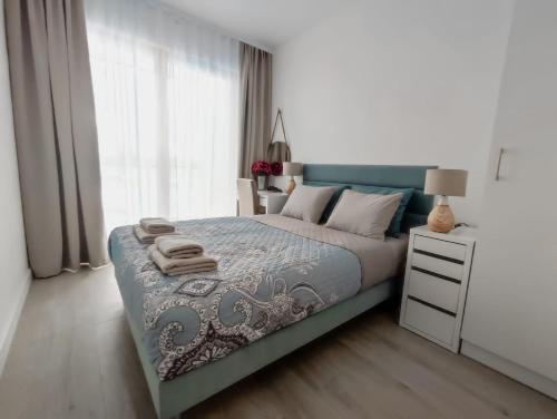 a bedroom with a bed with a blue and white bedspread at Porto in Gdańsk