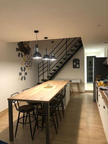 une cuisine avec une table et des chaises ainsi qu'un escalier dans l'établissement Une maison agréable pour se détendre, à Saint-Quentin