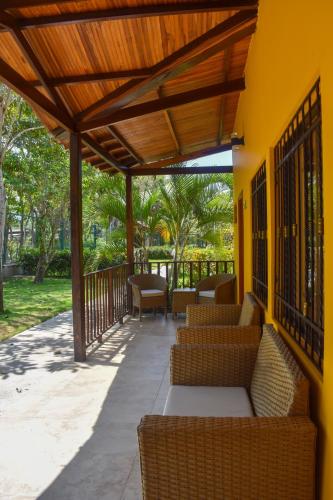 a patio with wicker chairs and a wooden pergola at Senderos del Mar - Tayrona in Buritaca