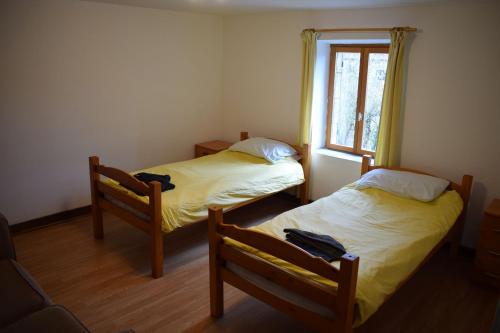 2 camas en una habitación con ventana en Chambre d'hôtes de puy faucher en Arrènes
