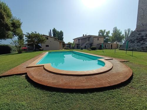 a swimming pool in a yard with a grass field at Pietra Rosa in Spello