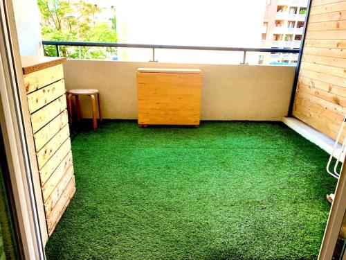 een kamer met een bureau en groen tapijt op een balkon bij Marseille 60 m2 terrasse et parking in Marseille
