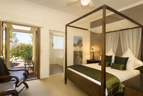 a bedroom with a canopy bed and a balcony at Plantation House at Whitecliffs Bed and Breakfast in Rye