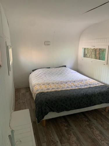 ein Schlafzimmer mit einem Bett in einem kleinen Zimmer in der Unterkunft CHALET AVEC SPA en fonction du 15 mai au 30 septembre in Lucciana