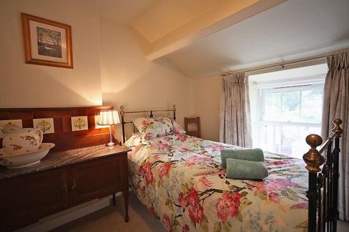 ein Schlafzimmer mit einem Bett und einem Fenster mit einer Schüssel darauf in der Unterkunft 1 Kirkbeck Cottage Coniston in Coniston