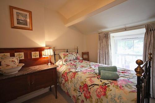 a bedroom with a bed and a window with a bowl on it at 1 Kirkbeck Cottage Coniston in Coniston