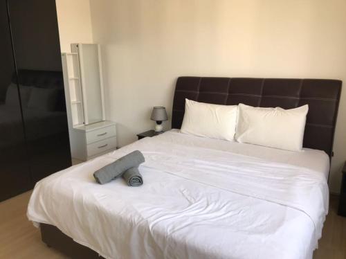 a bedroom with a large white bed with a black headboard at 118 Residences by Travovo in George Town