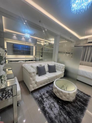 Sala de estar con sofá blanco y mesa de centro en MiamiViceLuxuryStays at Shore2, en Manila