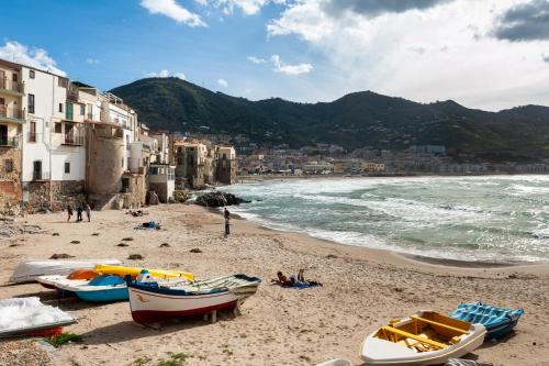 een strand met boten op het zand naast het water bij Ta Maison Al Molo in Cefalù
