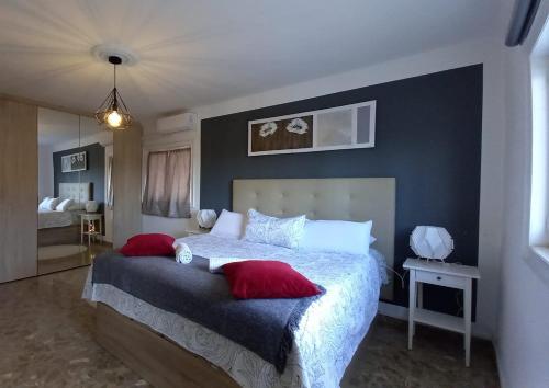 una camera da letto con un grande letto con cuscini rossi di Villa Paraiso - Appartement 2 pièces privatif ad Alhaurín de la Torre