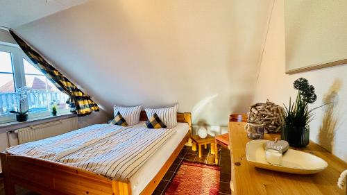 1 dormitorio con cama, mesa y ventana en Küstenliebe, en Norden