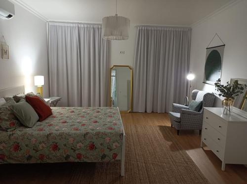 a hotel room with a bed and a chair at Santo Cristo Apartments in Ponta Delgada