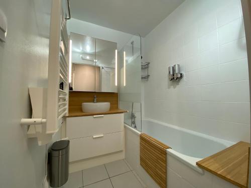 a white bathroom with a sink and a tub at Sol-y-Days Mayflower, Appartements bien équipés et climatisés, résidence avec piscine in Le Grau-du-Roi