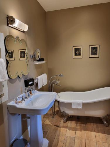 une salle de bain avec une baignoire et un lavabo dans l'établissement Hotel Vendome - BW Signature Collection, à Vendôme