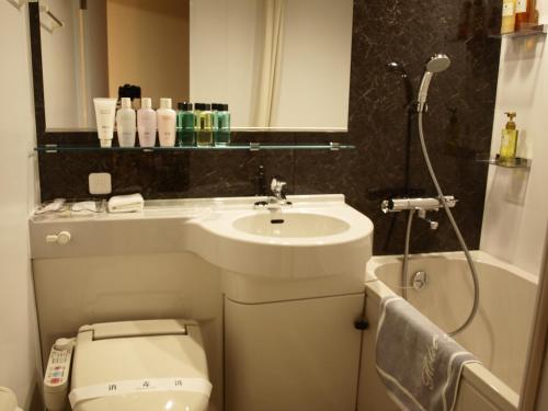 a bathroom with a sink and a toilet and a shower at Niseko Hot Spring Ikoino Yuyado Iroha in Niseko