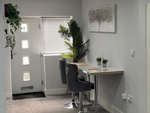 a office with a desk with two chairs and a plant at 10 St Andrews in Lytham St Annes