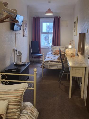 a room with a bed and a desk and a table at 140 Bond in Blackpool