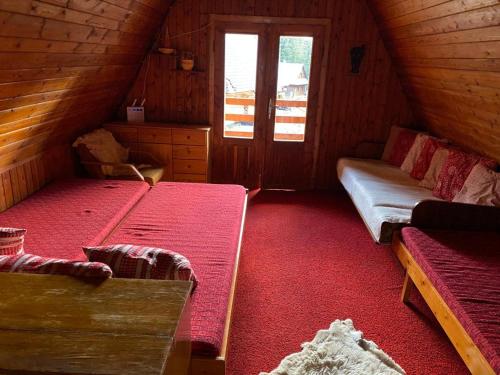 a attic room with two beds and a window at Chata Hugo in Jarabá