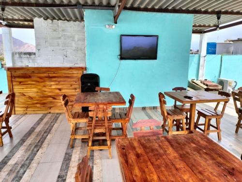 a room with wooden tables and chairs and a tv at Hotel Las Vegas by CMS hotels in Santa Marta
