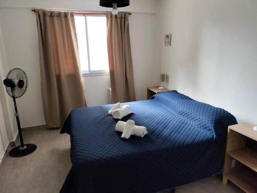- une chambre avec un lit bleu et 2 serviettes dans l'établissement Sun Apart, à Salta