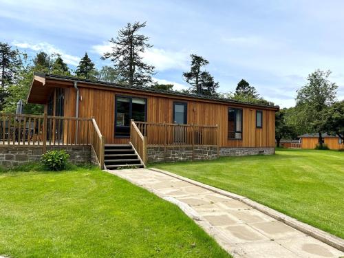 a house with a large yard in front of it at Skyline Lodge Loch Lomond Castle Lodges in Balloch