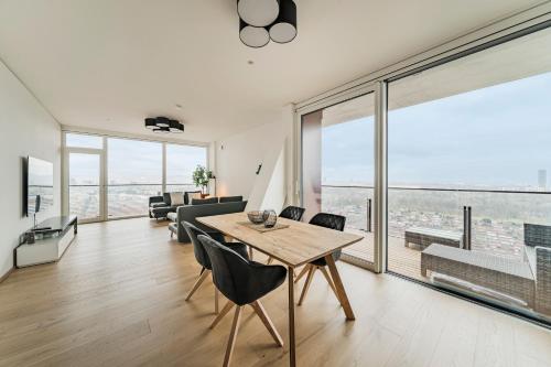 een woonkamer met een tafel en stoelen en een groot raam bij Diamondview LUXURY Apartments Vienna in Wenen