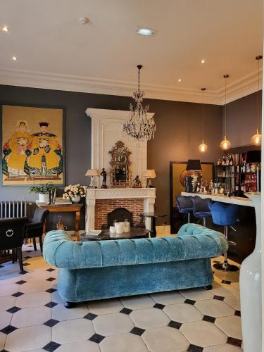 un salon avec un canapé bleu et une cheminée dans l'établissement Hotel Vendome - BW Signature Collection, à Vendôme