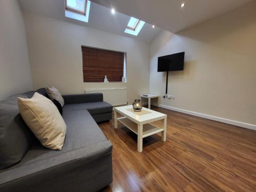 Great Apartment Next To Tooting Bec Tube Station! في لندن: غرفة معيشة مع أريكة وطاولة