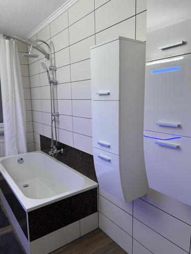 a white bathroom with a sink and a shower at O&V Apartment in Waldshut-Tiengen