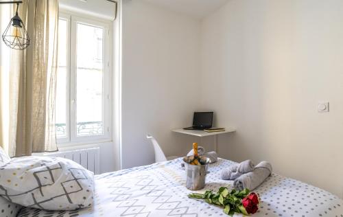 a bedroom with a bed with a flower arrangement on it at Le Charmant Appartement au coeur du BLAYAIS in Blaye