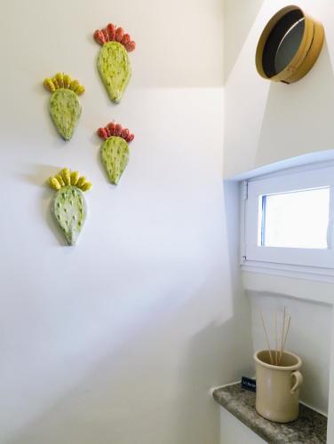 a wall with four artichoke hearts hanging on a wall at Le Nicchie - Ospitalità di Puglia in Bisceglie