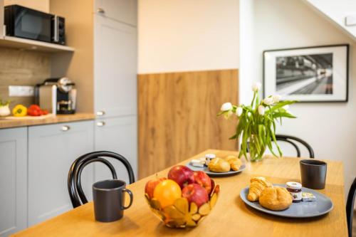a table with two cups and a bowl of fruit at Jimmy's Apartments Lory in Vienna