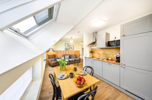a kitchen and dining room with a wooden table and chairs at Jimmy's Apartments Lory in Vienna