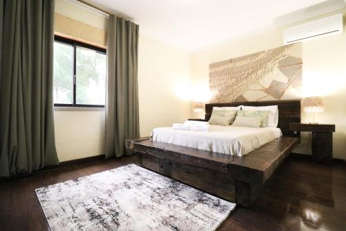um quarto com uma cama grande e uma cabeceira em madeira em Charme Lusitano Countryside Experiences em Inguias