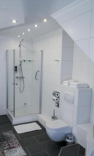 a white bathroom with a shower and a toilet at Arthotel ANA Liberty Bremen City in Bremen